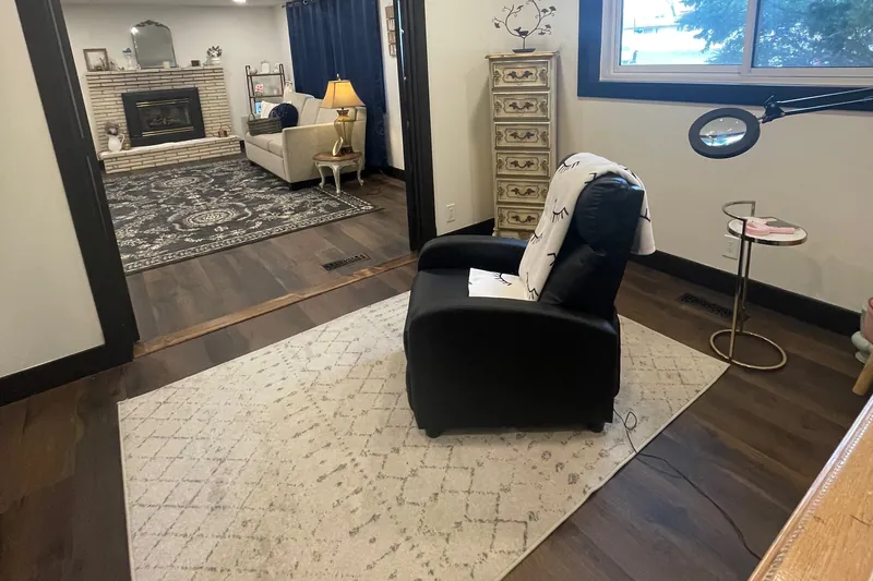 The lash recliner and magnifying lamp, with the lounge and fireplace beyond